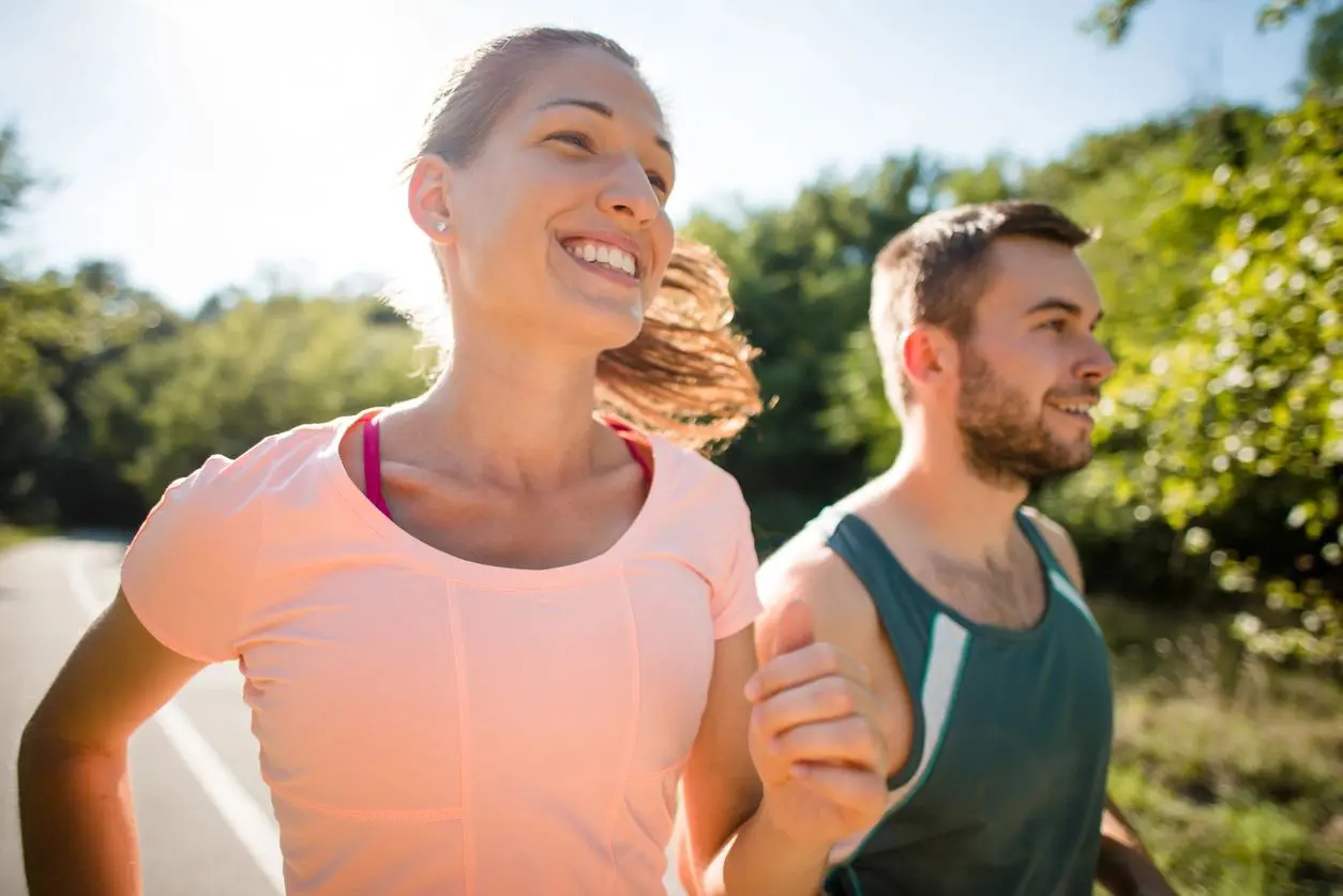 A man and woman running in the park.