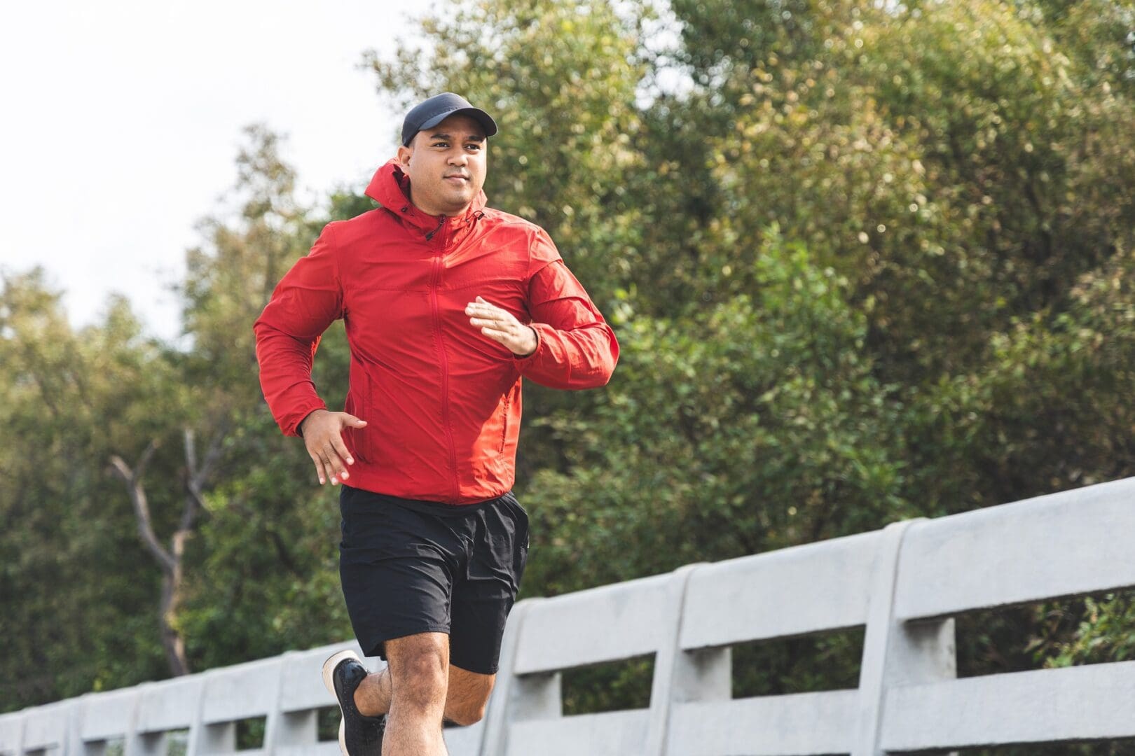 A man running on the side of a bridge.