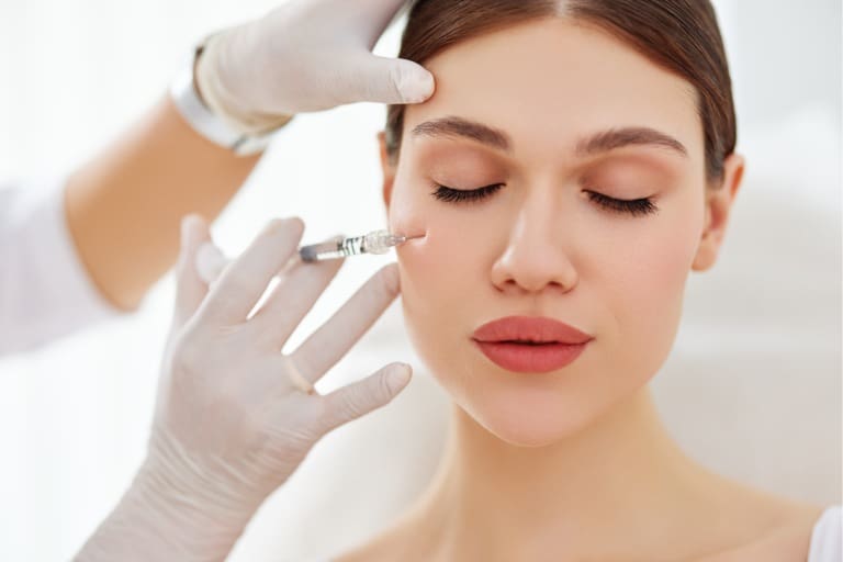 A woman getting her face botox injection in the middle of her face.